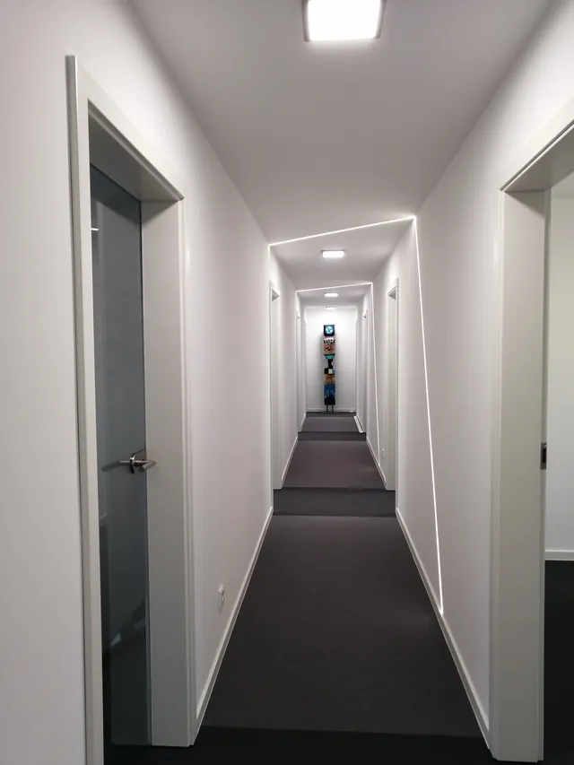Umgebaute Büroflächen in Fallersleben: heller Flur mit Lichtfugen in Wand und Decke